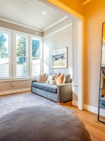 Gemütlicher Loungebereich mit Sofa und großen Fenstern