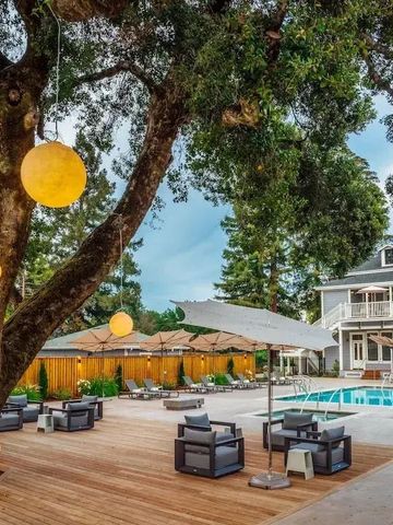 Außenbereich mit Pool, modernen Sitzmöbeln und beleuchteten Bäumen