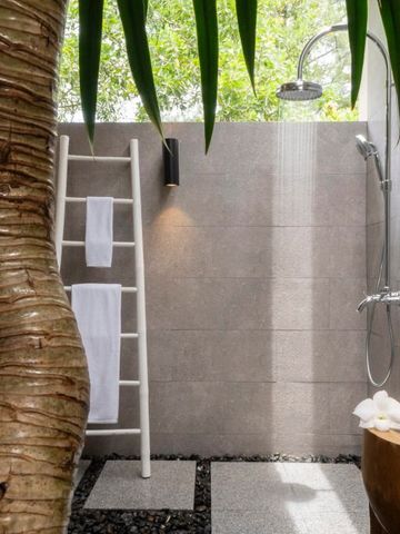 Offene Außendusche mit tropischer Vegetation und natürlichem Ambiente.