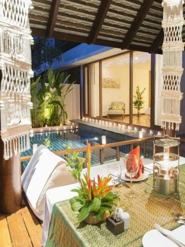 Outdoor-Gedeck am Pool in tropischer Umgebung mit stimmungsvoller Beleuchtung