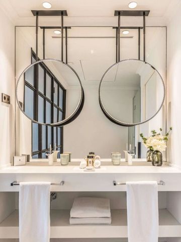 Modernes Badezimmer mit zwei runden Spiegeln und eleganter Dekoration