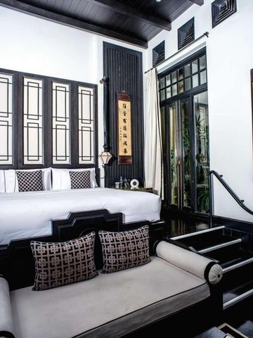 Luxuriöses Schlafzimmer im The Siam Hotel mit großer Fensterfront und Dekoration