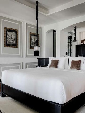 Helles und elegantes Schlafzimmer im The Siam Hotel mit klassischen Designelementen