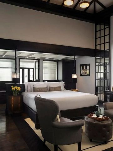 Elegantes Zimmer mit großem Bett, modernen Möbeln und stilvollem Dekor