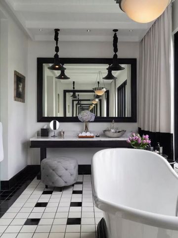 Luxuriöses Badezimmer mit freistehender Badewanne und großem Spiegel im Hotel.