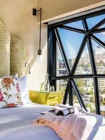 Gemütliches Bett mit Blick auf die Stadt im The Silo Hotel Kapstadt