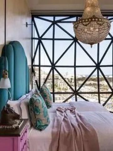 Luxuriöses Schlafzimmer mit einzigartigem Fensterdesign im Silo Hotel
