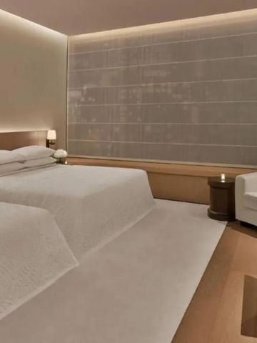 Modernes Hotelzimmer mit zwei Betten und sanfter Beleuchtung.