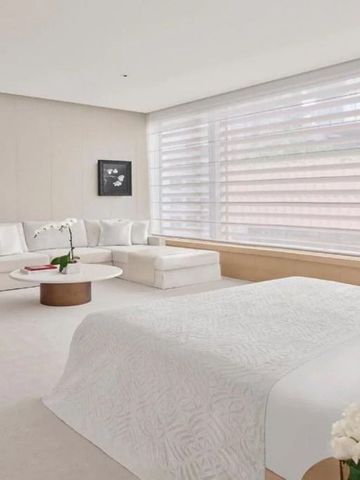 Elegantes Zimmer mit großer Fensterfront und gemütlicher Sitzecke.