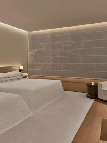 Elegantes Hotelzimmer mit zwei Doppelbetten und moderner Beleuchtung