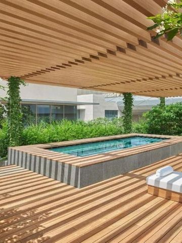 Jacuzzi auf hölzerner Terrasse mit überdachtem Bereich und Pflanzen