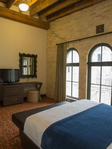 Gemütliches Gästezimmer mit Holzbalkendecke und großen Fenstern