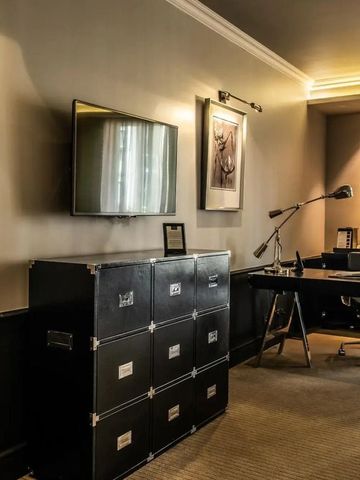 Modernes Arbeitszimmer mit Schreibtisch und TV im Hotelzimmer.