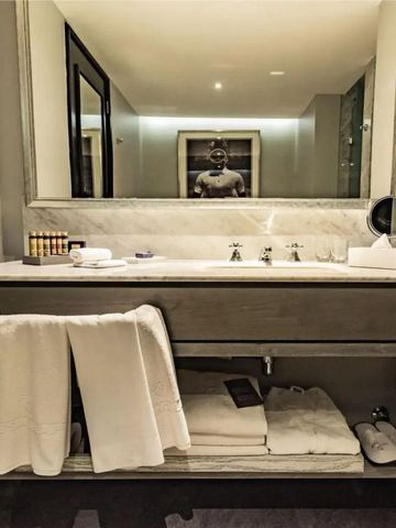 Luxuriöses Badezimmer mit großem Spiegel und hochwertigen Pflegeprodukten.