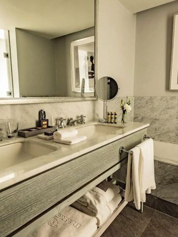 Modernes Badezimmer mit Doppelwaschbecken und Dekorationen aus Marmor.