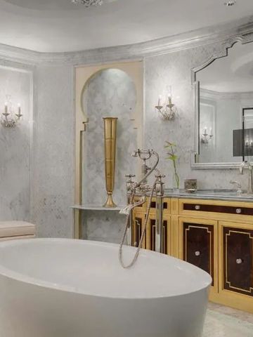 Luxuriöses Badezimmer mit freistehender Badewanne und goldenen Akzenten
