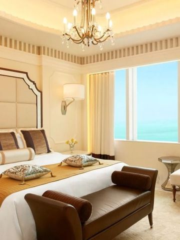 Luxuriös eingerichtetes Schlafzimmer mit Kingsize-Bett und Meerblick, helle Farben