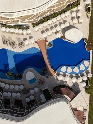 Luftaufnahme von kunstvoll gestaltetem Außenpoolbereich mit Liegestühlen