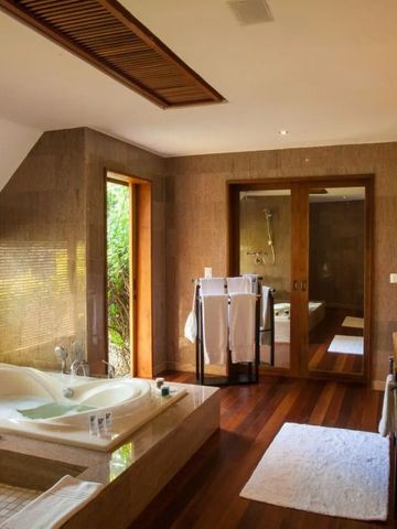 Luxuriöses Badezimmer mit Whirlpool und Holzdetails im Resort