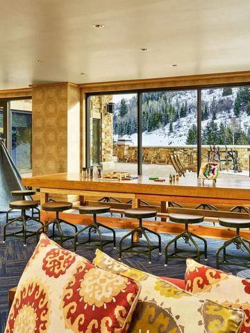 Heller Kinderbereich mit großen Fenstern und Blick auf verschneite Berge.