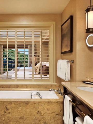 Luxuriöses Badezimmer mit Badewanne und Aussicht auf die Terrasse.