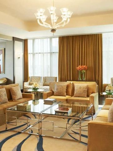 Geschmackvoll eingerichtetes Wohnzimmer in warmen Tönen im The St. Regis Doha