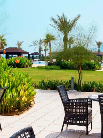 Gartenbereich mit Palmen und Sitzgelegenheiten im Freien, Blick auf Pool