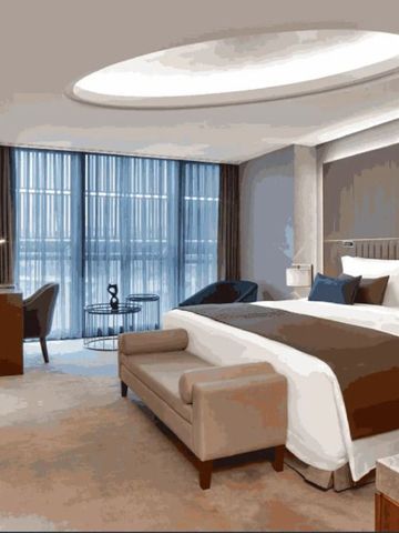 Luxussuite mit Kingsize-Bett, stilvollem Dekor und großen Fensterfronten