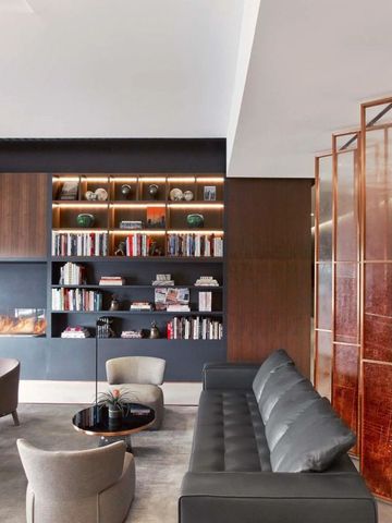 Elegante Lounge mit Bücherschrank und Kamin