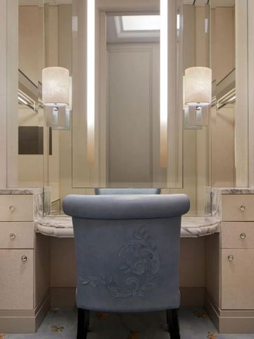 Stilvoller Ankleidebereich mit schmuckem Stuhl und edlen Oberflächen.