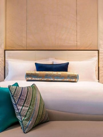 Stylisches Hotelbett mit dekorativen Kissen und dezenter Beleuchtung