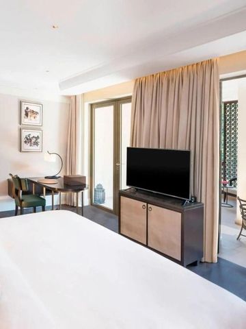 Helles Zimmer mit großem Bett und Balkon mit luxuriösem Dekor