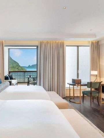 Zwei große Betten in einem Zimmer mit Blick auf das Meer