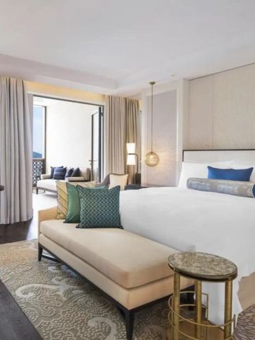 Luxuriöses Hotelzimmer mit Kingsize-Bett und Balkon in warmen Farben