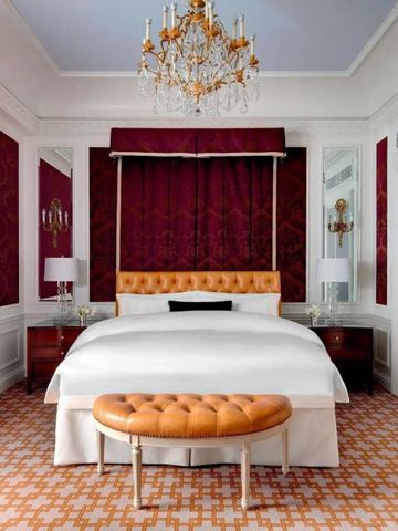 Elegantes Hotelzimmer mit Kronleuchter und rotem Dekor