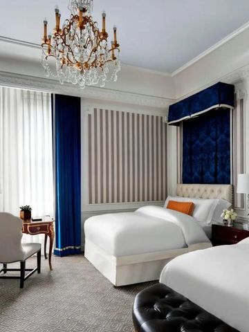 Zweibettzimmer mit blauem und weißem Dekor und Kristallleuchter