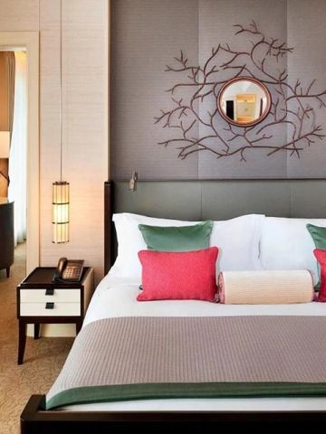 Luxuriöses Hotelzimmer mit dekorativem Kunstwerk über dem Bett und eleganter Einrichtung