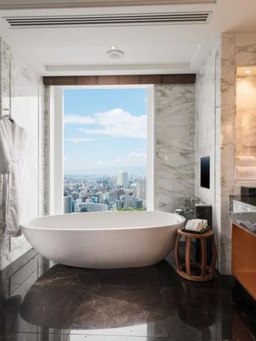 Modernes Bad mit freistehender Wanne und Panoramablick auf die Stadt