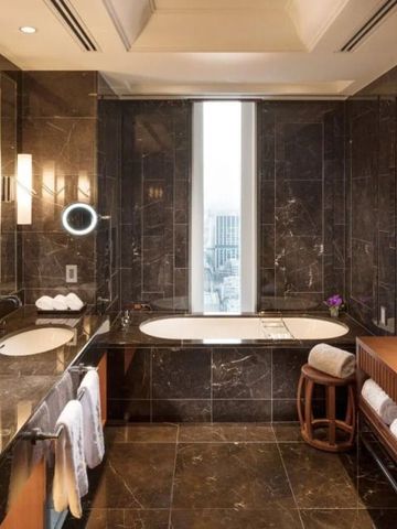 Elegantes Badezimmer mit dunklen Marmorelementen und Doppelwaschbecken