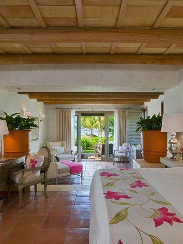 Helles Zimmer mit Holzdecke, großen Fenstern und tropischem Dekor