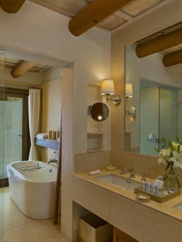 Luxuriöses Badezimmer mit freistehender Badewanne und Holzelementen.