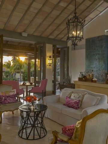 Eleganter Lounge-Bereich mit geöffneter Veranda und Blick auf den Sonnenuntergang.