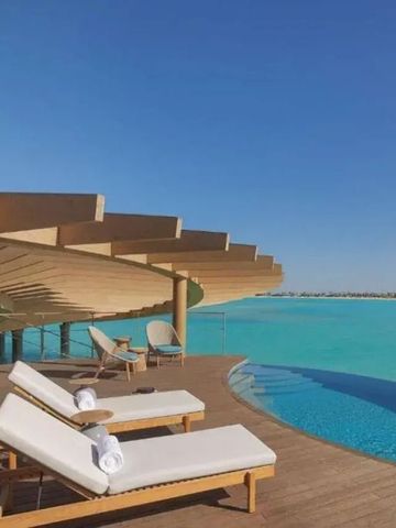 Infinity-Pool mit Blick auf das Meer, umgeben von Sonnenliegen