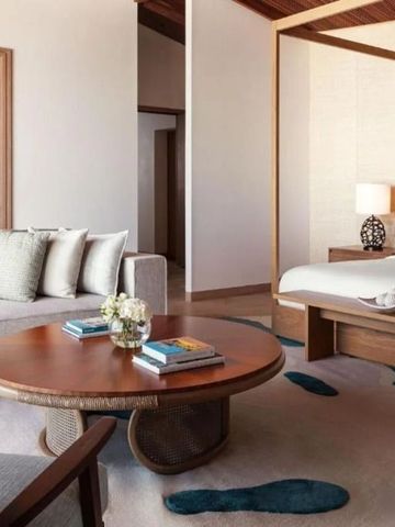 Elegantes Zimmer mit Sofa, Tisch und großem Bett im Resort