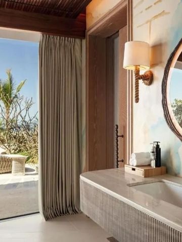 Luxuriöses Badezimmer mit direktem Zugang zur Terrasse und Strandblick