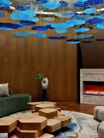 Loungebereich mit blauem Kunstwerk an der Decke und Kamin