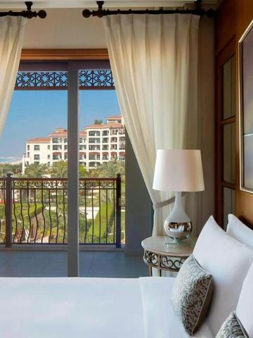 Hotelzimmer mit Terrasse und Ausblick auf Garten und Gebäude