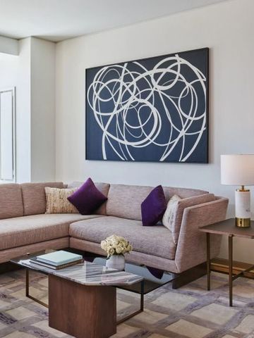 Modern eingerichtetes Wohnzimmer einer Suite mit Sofa und Kunstwerk an der Wand