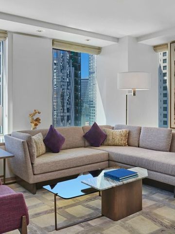 Helles Wohnzimmer in einer Suite mit Stadtblick durch große Fenster