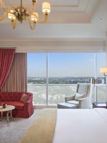 Grandioses Zimmer mit großem Fenster, stilvoller Einrichtung und komfortablen Sitzgelegenheiten